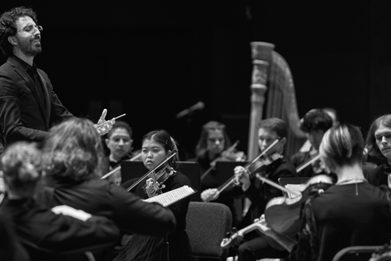 A conductor conducts the summer orchestra, photo by Darrell Owens