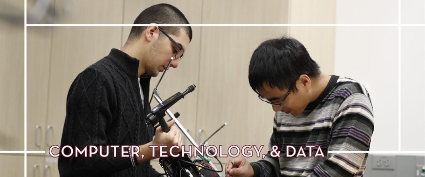 Two students working hands on a piece of technology