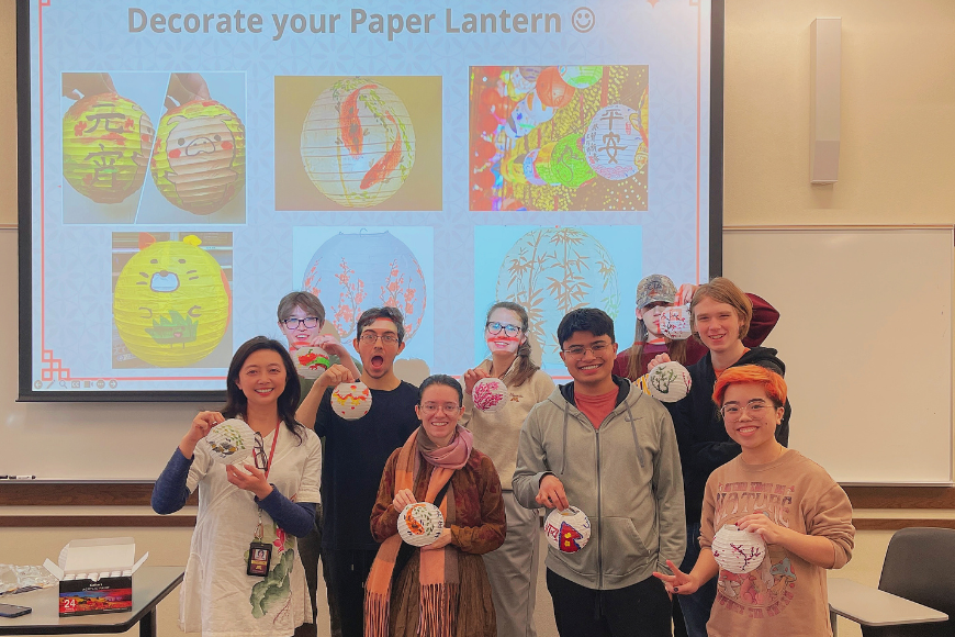 Students pose next to their decorated paper lanterns