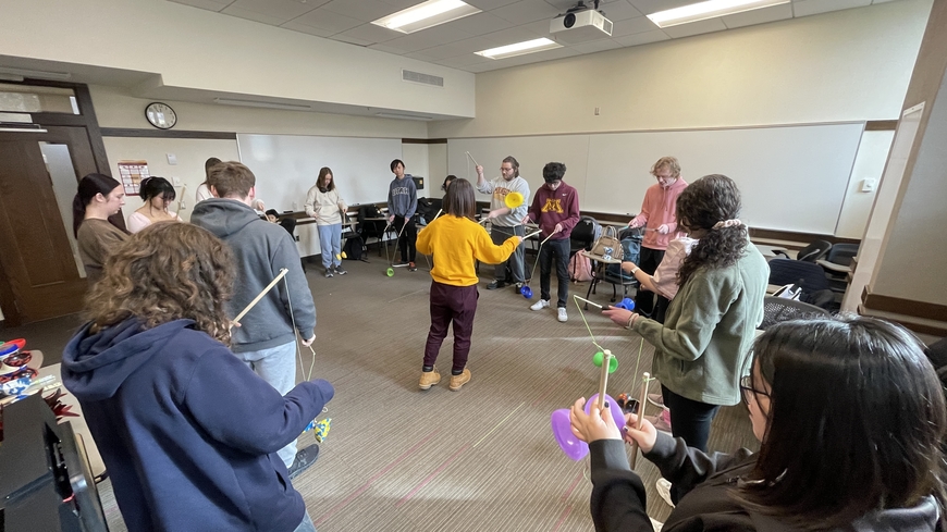 The class learns how to play a Chinese yoyo and kick a shuttlecock.