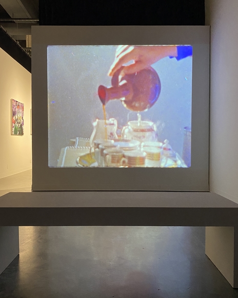 Projection in art gallery of person pouring tea