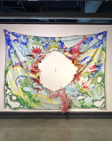Painted textile installation with large circular hole showing white wall behind it