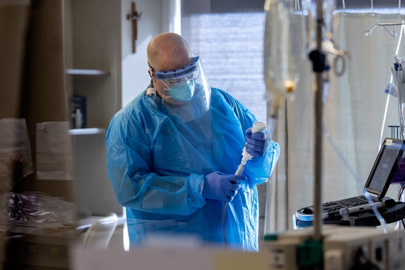 A doctor wearing personal protective equipment in an intensive care unit