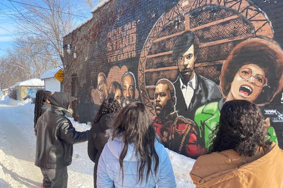 CLA students stand in front of mural of Black leaders.