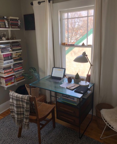 Photo of PhD candidate Andrew Hamilton's home office, with a clear glass desk below a window