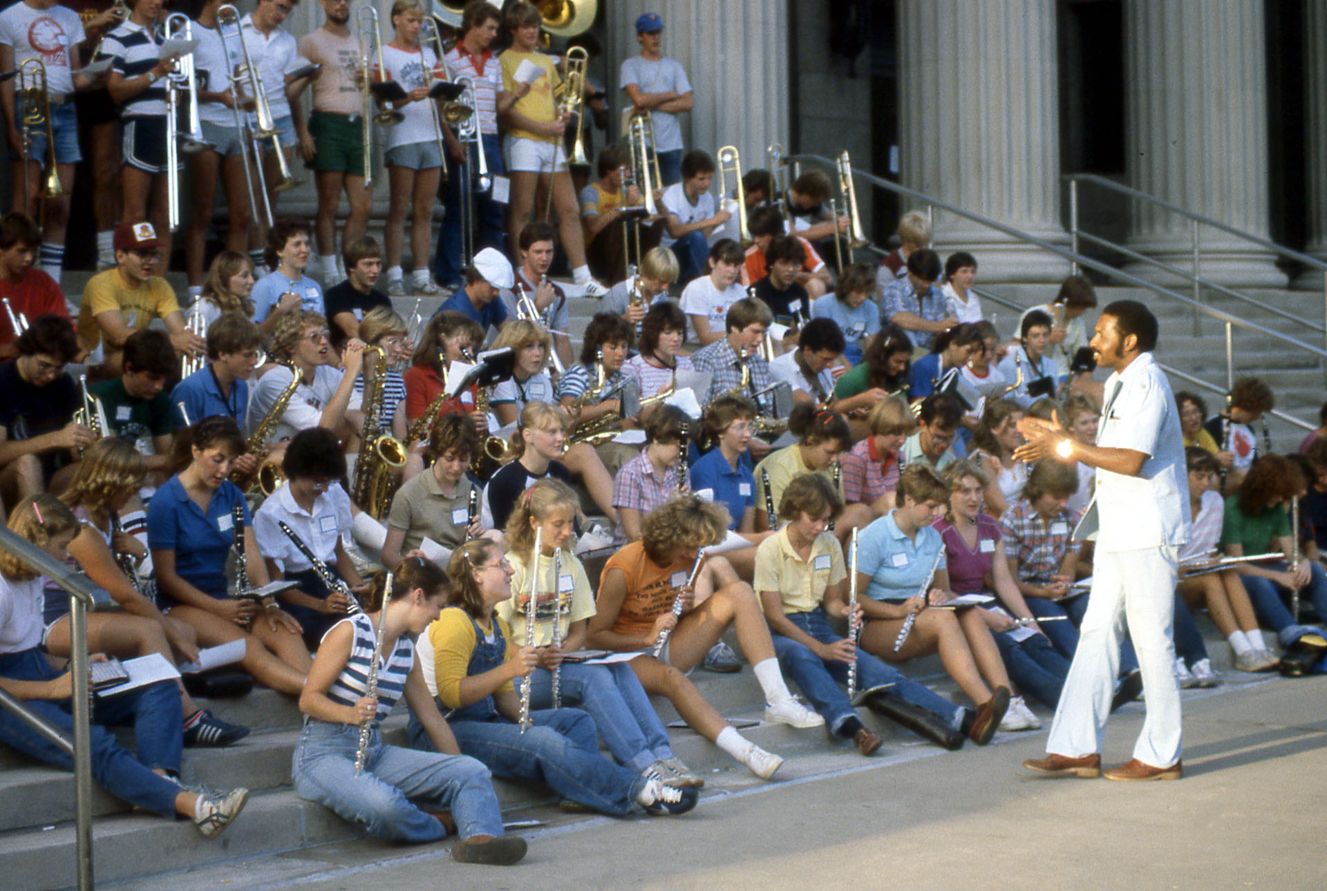 O'Neill Sanford stands in front of a large group of marching band students in 1982. 