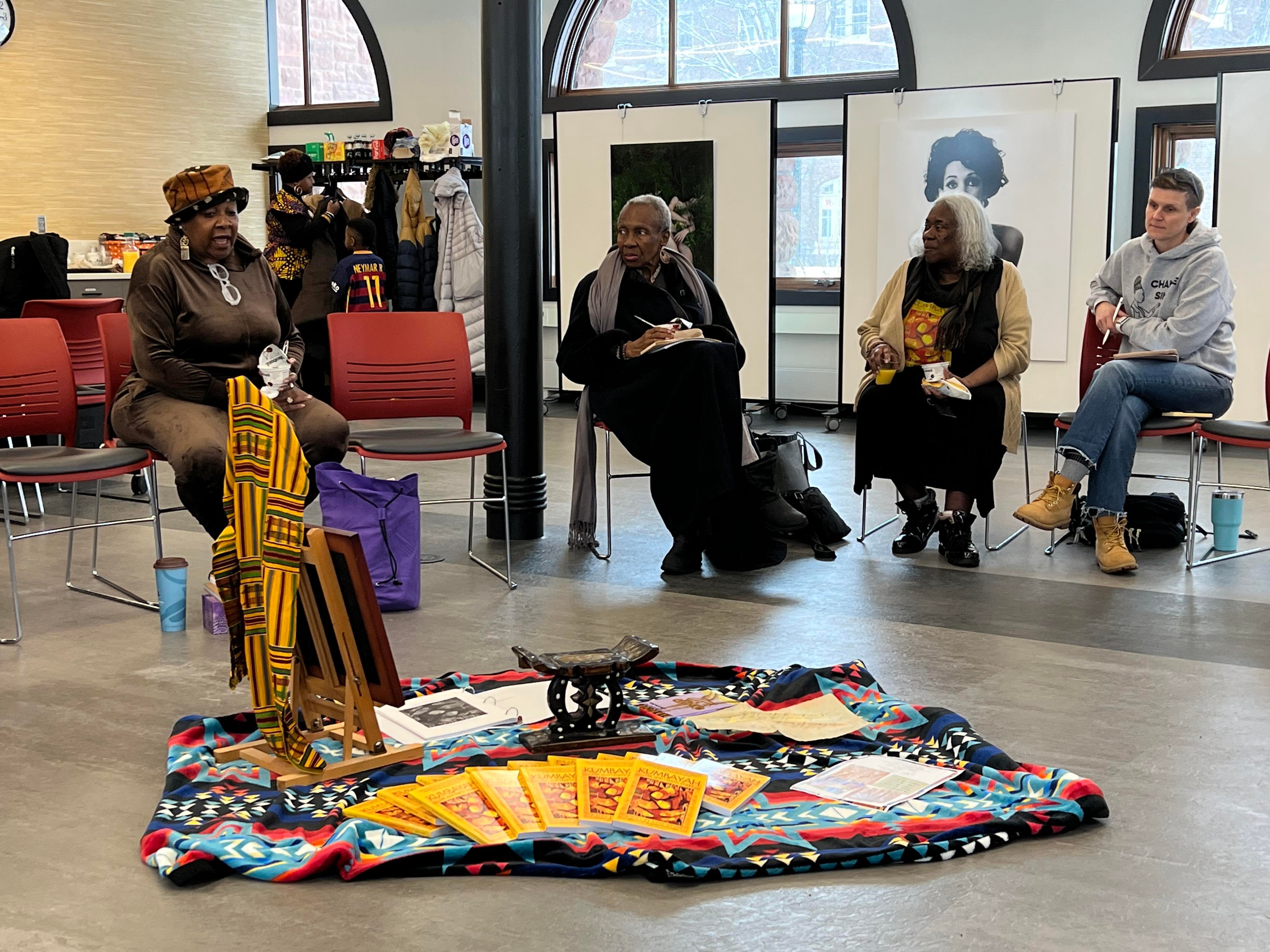 Rose McGee and community elders sit in a semi-circle at the Hub during one of the "Story Circles."