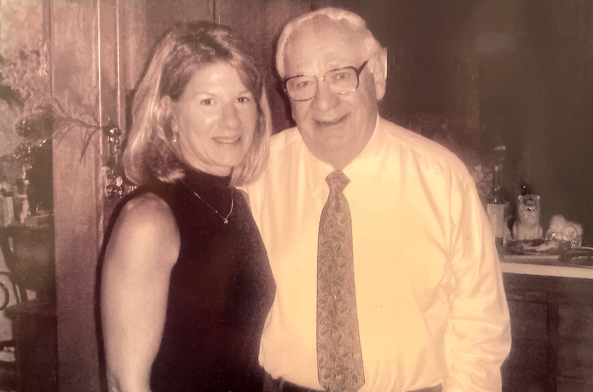 Dominick Argento's Niece, Nicki Rambeau (left) is in a black dress posing with Dominick Argento (right) wearing a white shirt with tie.