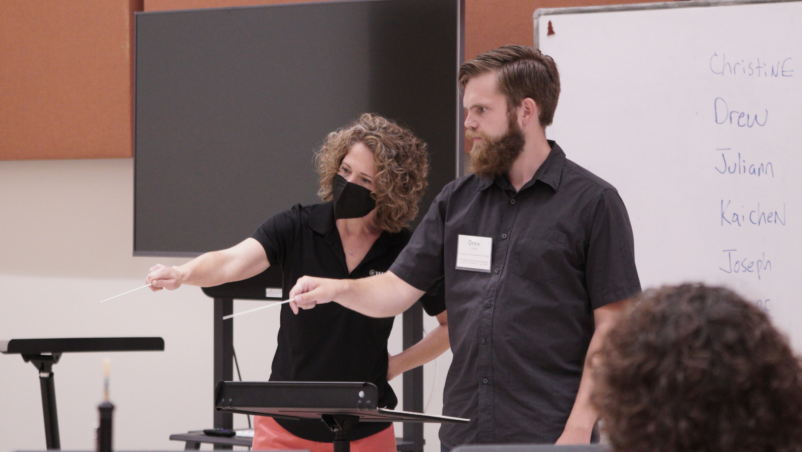 Emily Threinen leads a participant in a conducting exercise. 