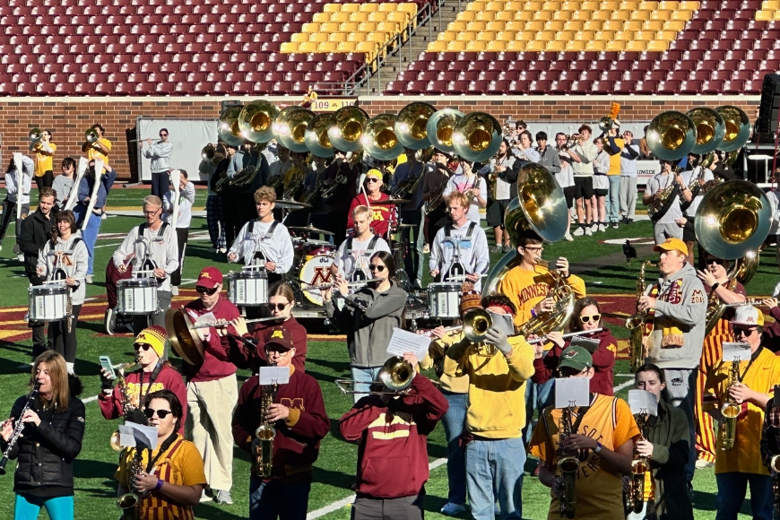 Chad Smith rehearsing on the field with marching band students. 