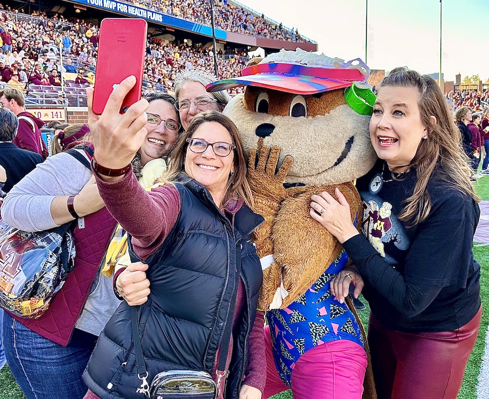 Trailblazers halftime participants pose for a selfie with Goldy Gopher. 