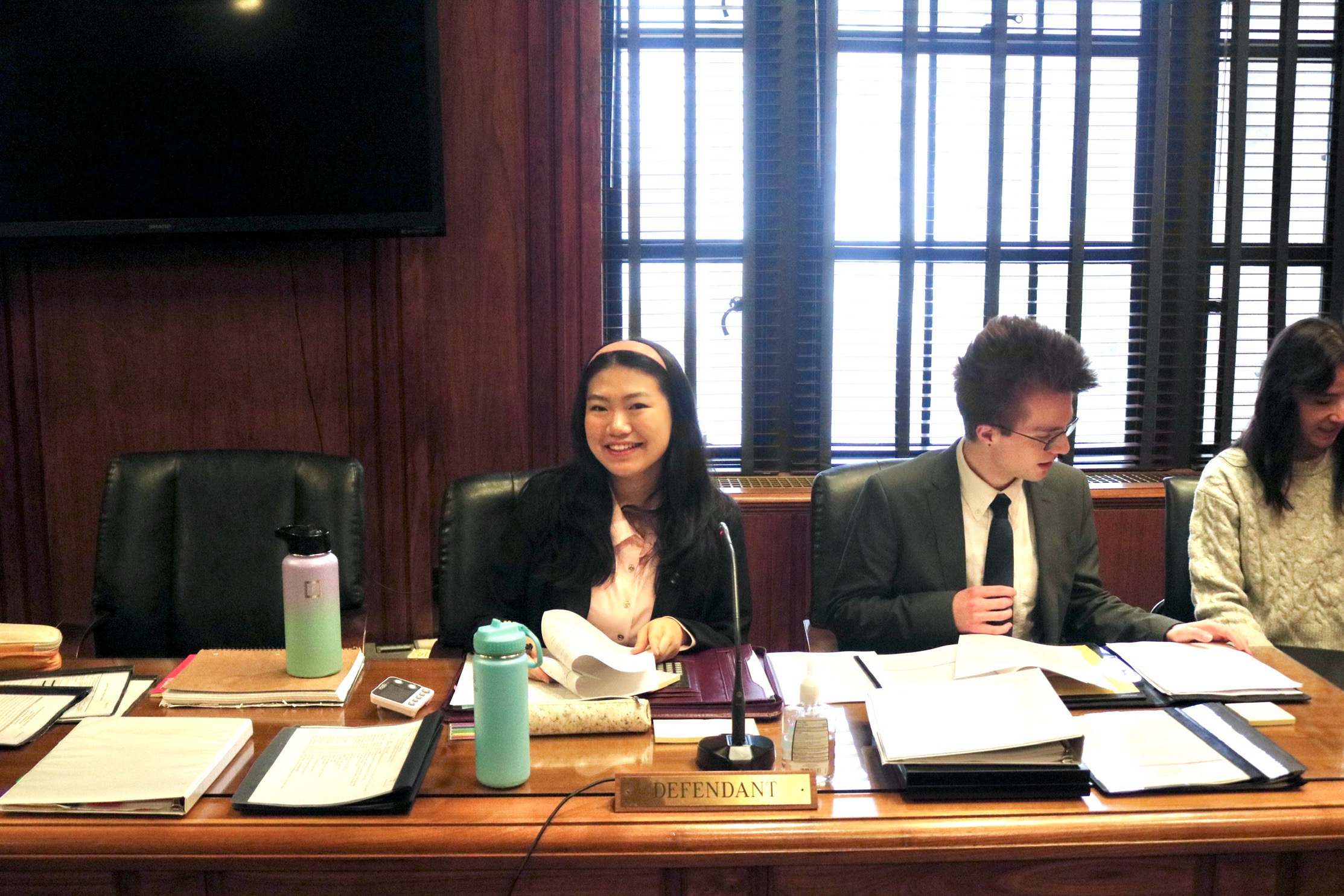 Jinhoung and two other students sitting at "Defendant" table for Mock Trial.