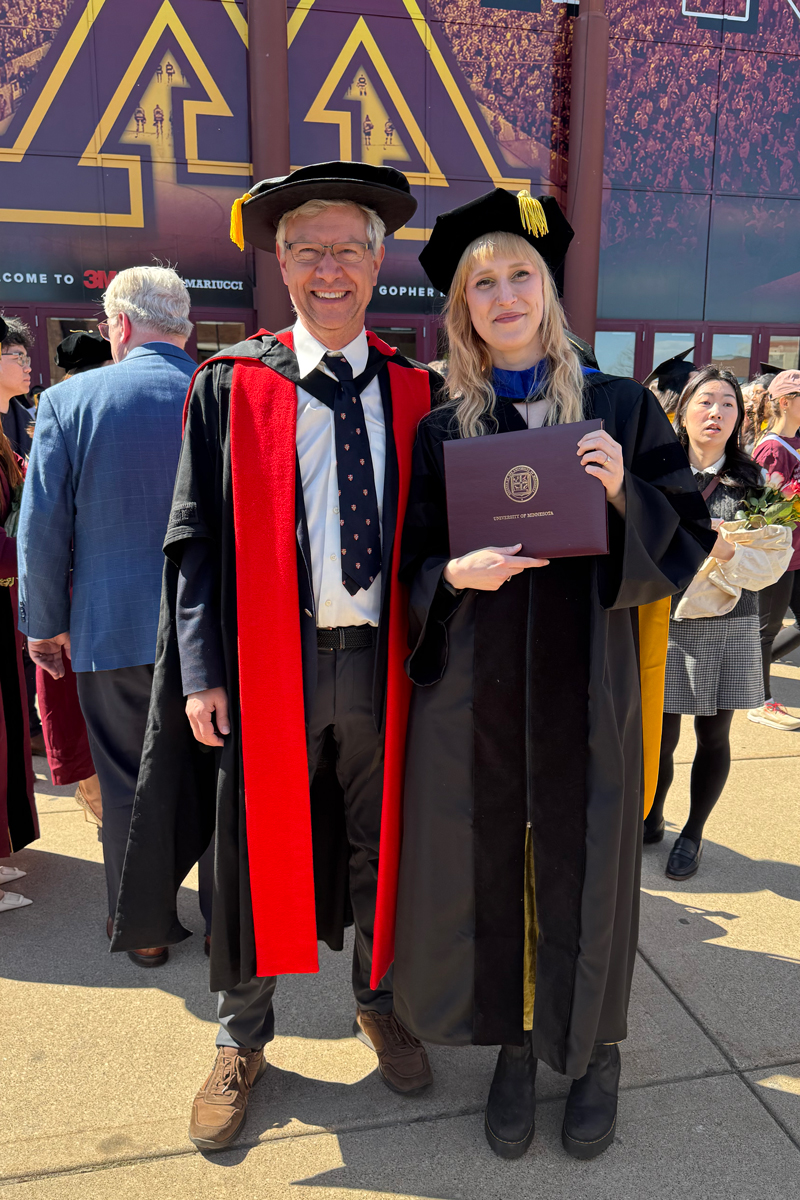 PHD graduate Lisanne Bogaard with adviser Andrew Oxenham in gown at graduation ceremony.