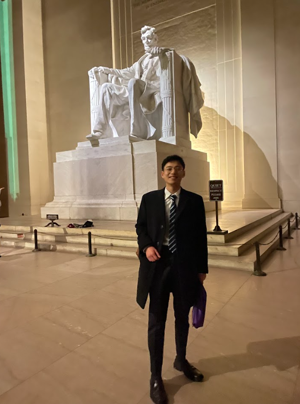 Khoi Phan wearing suit, standing in front of Lincoln Memorial