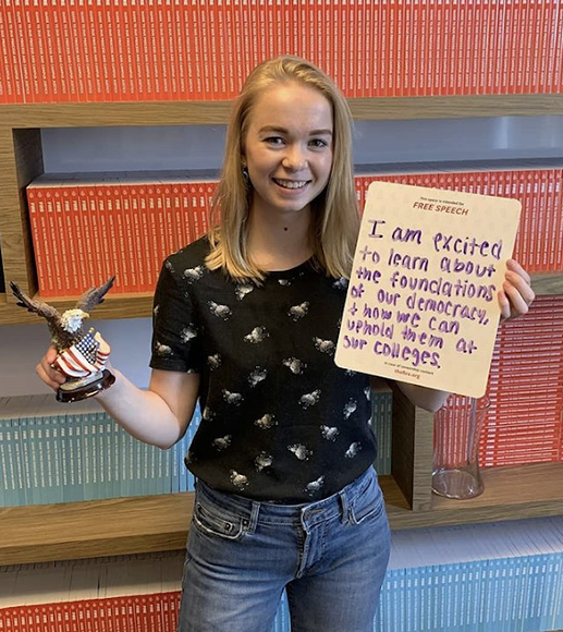 Margaux Granath holding small whiteboard and small bald eagle figure