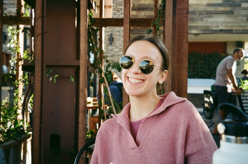 Photo of Julia Serio smiling and wearing sunglasses.