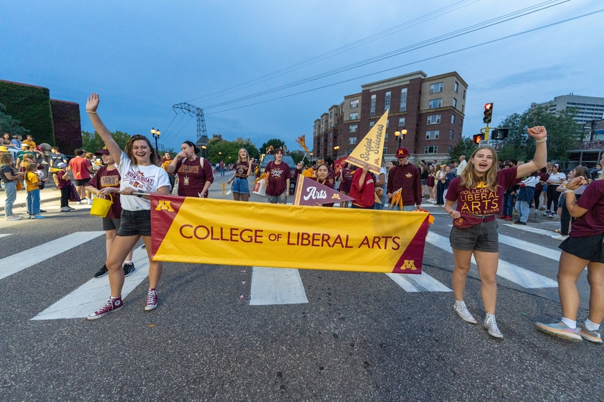 Students holding College of Liberal Arts banner in parade