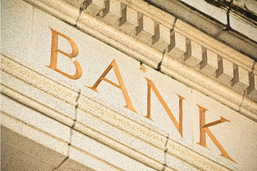 Close up photo of the word "bank" engraved on a stone building