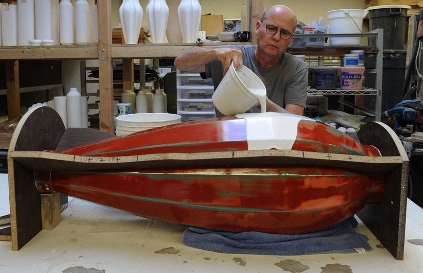 Tom Lane pours a mold for his 9/11 urn at a bench in his studio