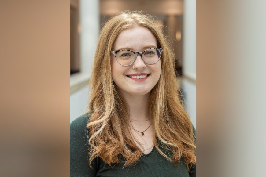 Young woman with ginger hair and glasses smiling