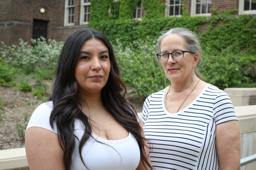 On the left, a young Indigenous woman with long black hair and a white shirt, on the right, an older white woman with gray hair and a striped shirt