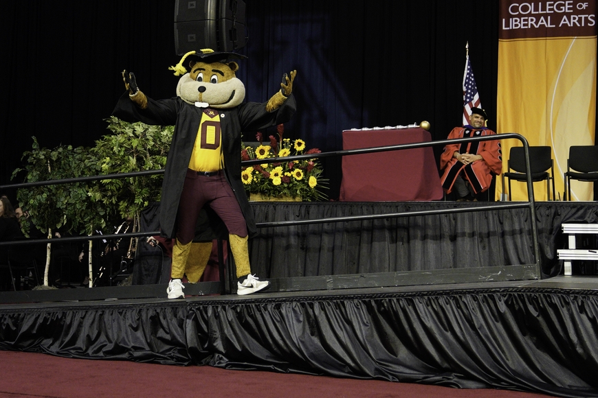 Goldy Gopher crossing the graduation stage