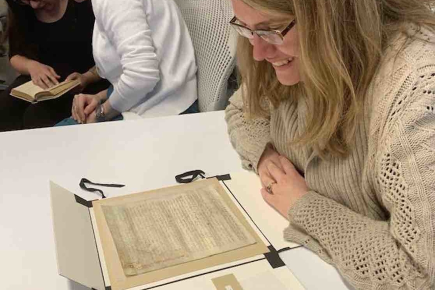 A graduate student in English consults a manuscript in HMML's archives