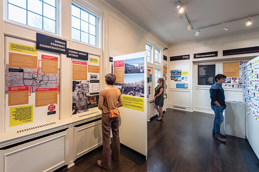 People looking at presentations displayed on panel walls at the Hennepin History Museum.
