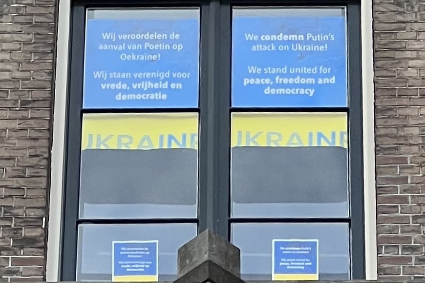 Window in the Humanities building at the University of Amsterdam with signs in Dutch and English supporting Ukraine.