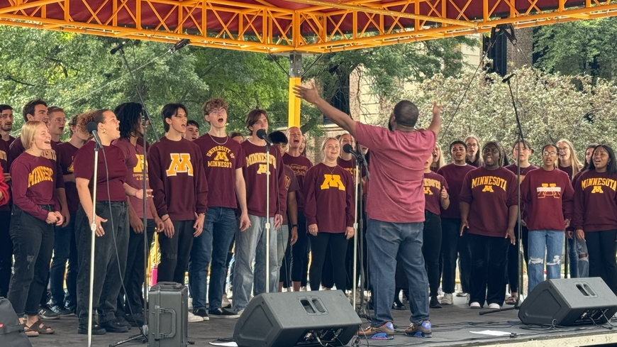 The Gospel Choir performs on a sunny day, conducted by Adrian Davis