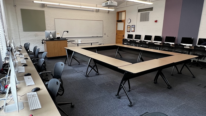 Small computer lab with tables in the middle of room