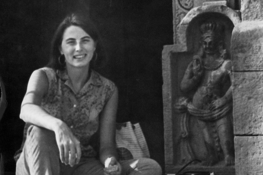 B&W photo of Catherine Asher seated next to Indian art