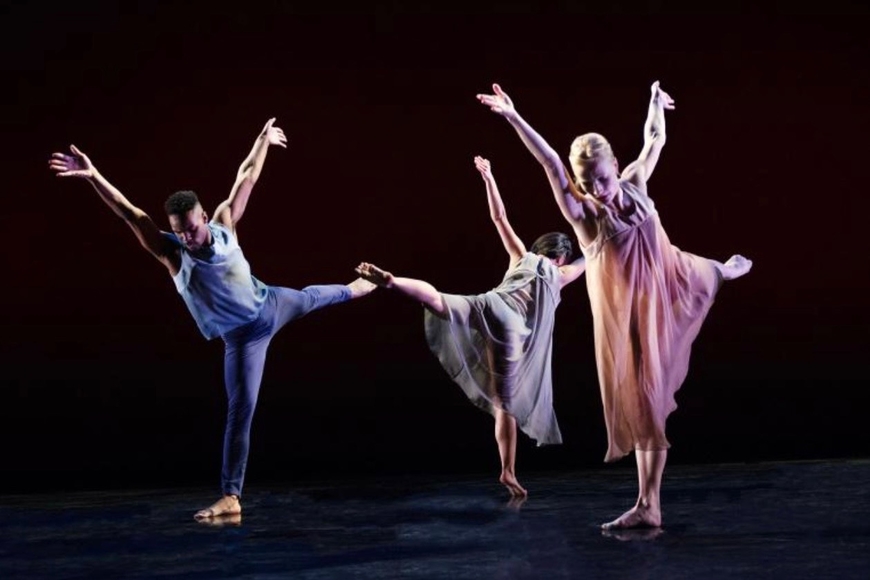 3 dancers standing on one leg with arms outstretched 