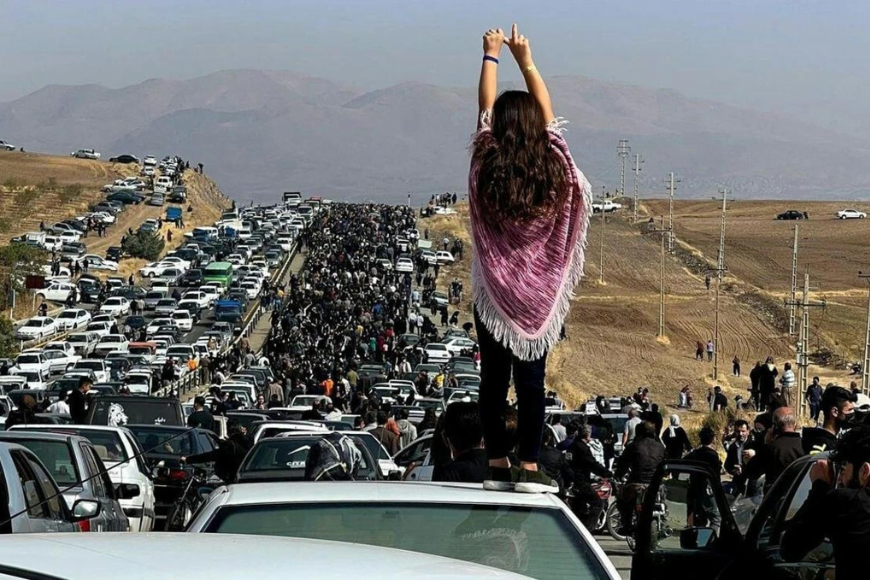 Iranian Protester standing on top of a car