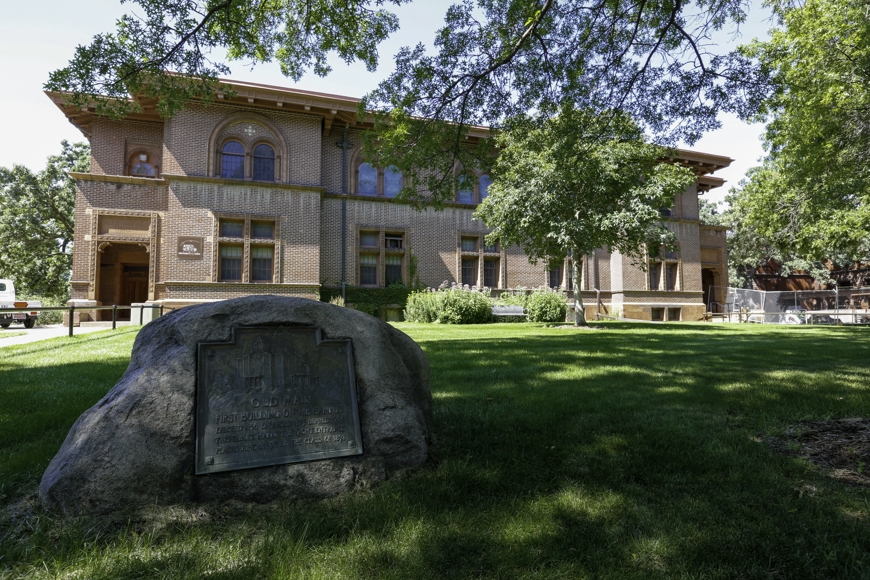 Boulder with commemorative sign in front of Shevlin Hall