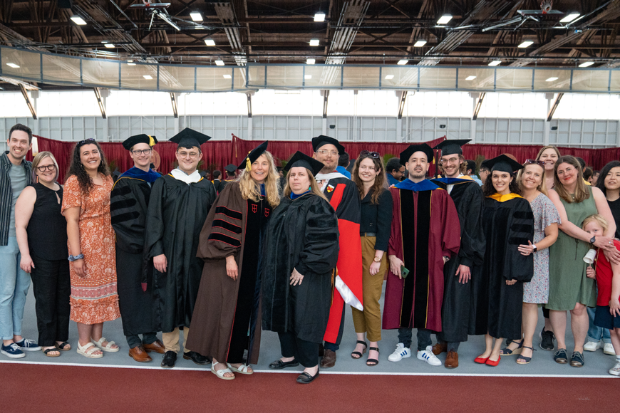 group of faculty and students in cap and gown during 2023 stage crossing event