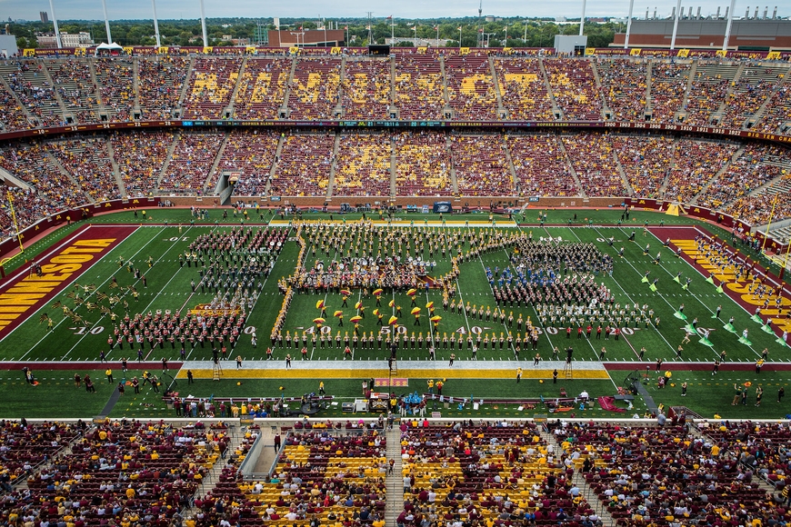 Marching Band students on the field at TCF Bank Stadium in a formation shaped like the state of Minnesota.