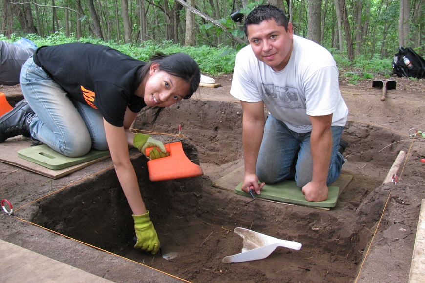 Two people around a research site in the ground