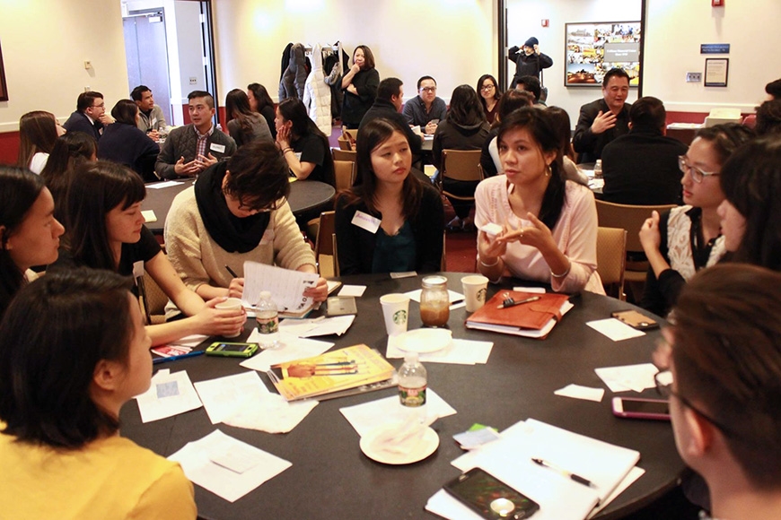 Asian American Studies students at a conference, seated around a table. 