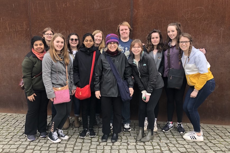 11 Students and professor in Berlin in front of brown wall