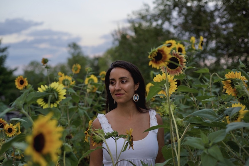 Caroline Fidan Tyler Doenmez walking through a field of sunflowers