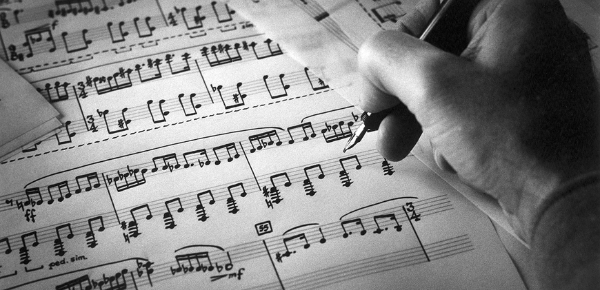 A hand working on music analysis