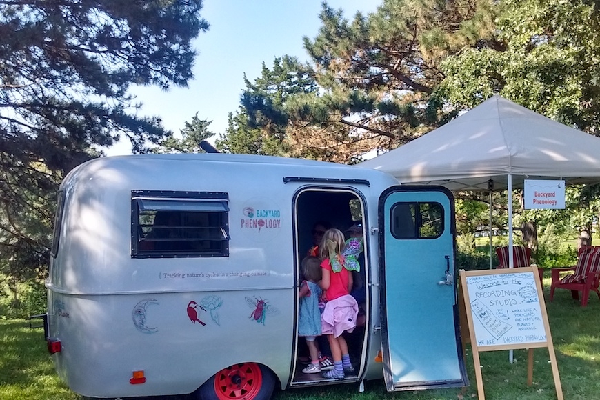 Two girls explore the Backyard Phenology Project’s Climate Chaser camper.