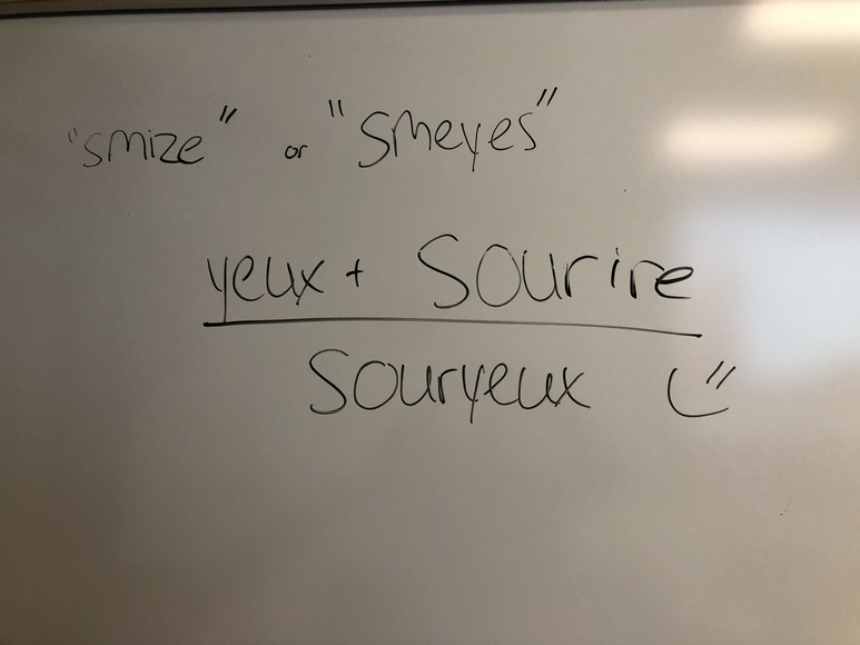 "yeux + sourire = souryeux" written on a whiteboard