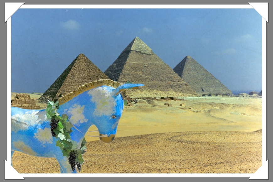 A sky-blue donkey sculpture in the foreground and three Egyptian pyramids in the background