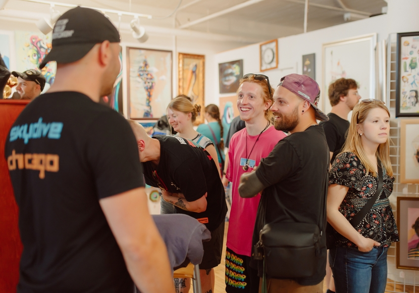 Smiling people talk in a crowded art studio