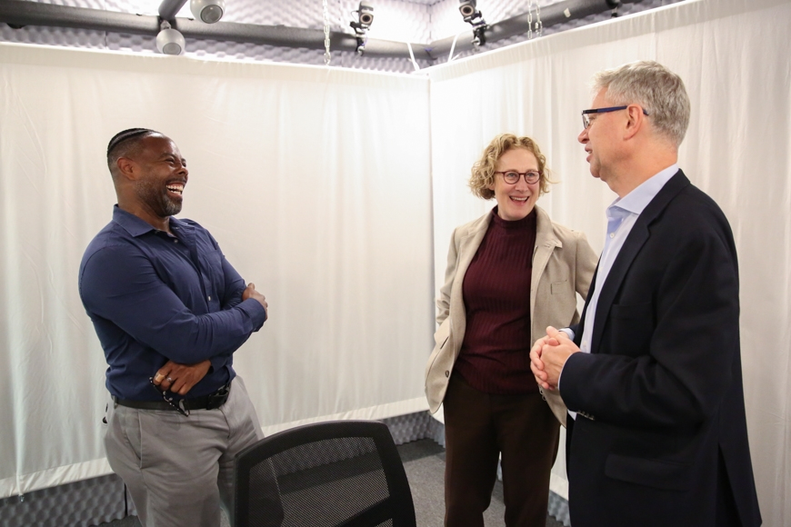 three faculty members talk in a sound booth