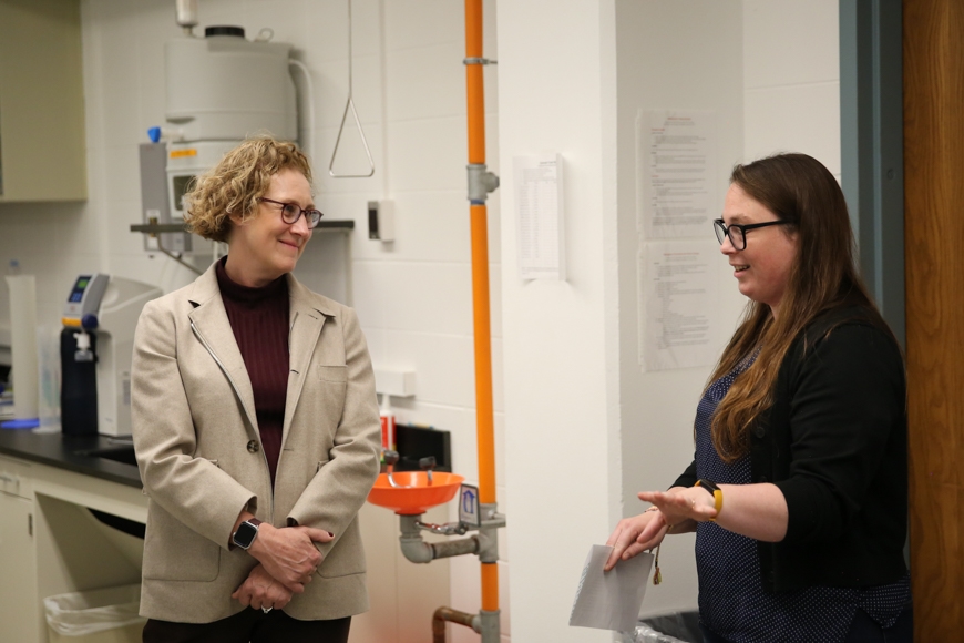 two women talk in a lab