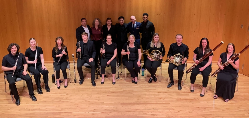 The chamber winds of the wind band conducting workshop pose with the faculty of the workshop. 
