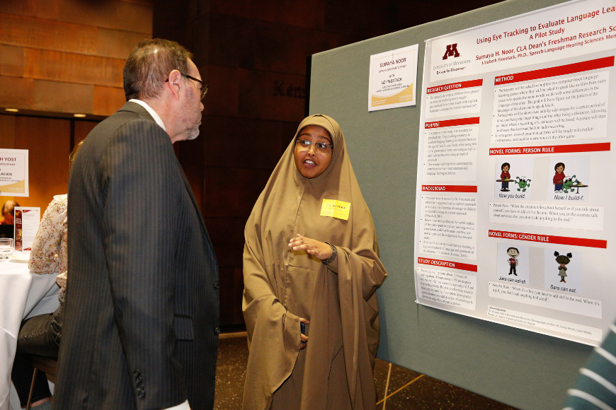 Dean Coleman listens as a student presents their research